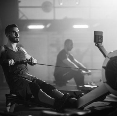 black-white-photo-sportsman-working-out-rowing-machine-during-cross-training-gym